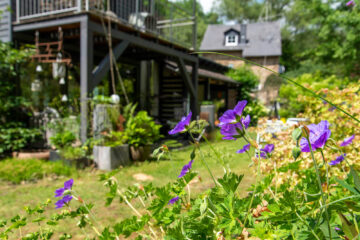 Der gepflegte Garten verfügt über gemütliche Gartenmöbel, Sonnenliegen und einen großen Sonnenschirm.